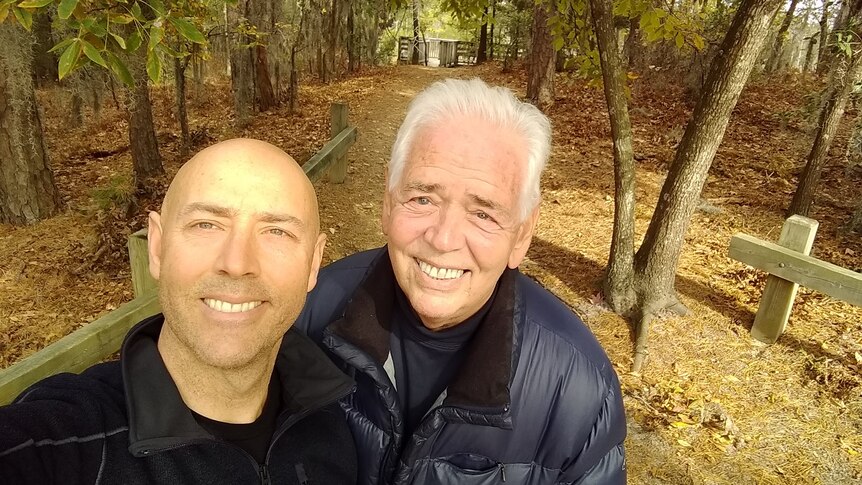 Father and son taking a selfie in a forest. 