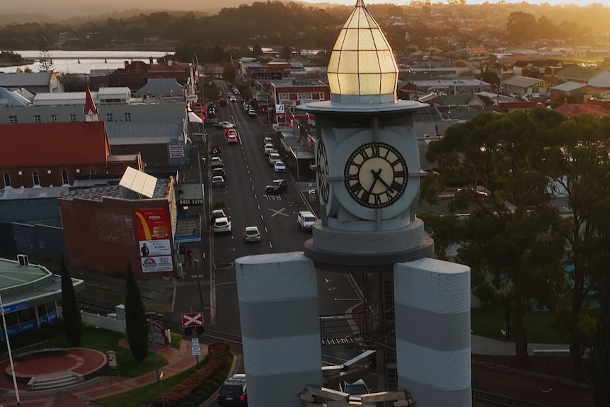 Drone view from the height of a clock tower looking back down main street of a town.