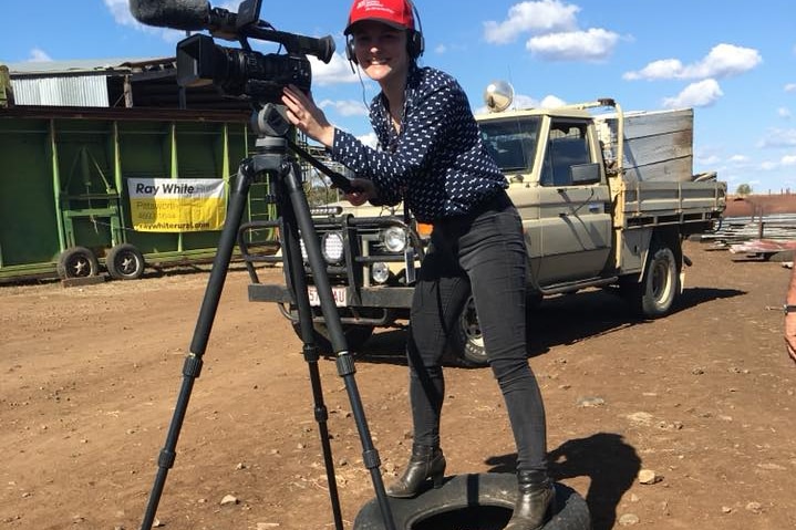 Journalist Sophie Volker filming a TV story while standing on a tyre.