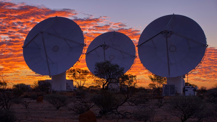 Under a sunset sky, three ASKAP telescopes are trained towards the sky east of Geraldton