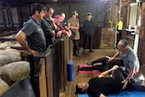 Pera Davies teaches shearer's yoga, while shearers watch.