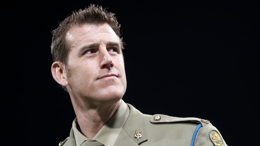a man wearing an army uniform looking sideways