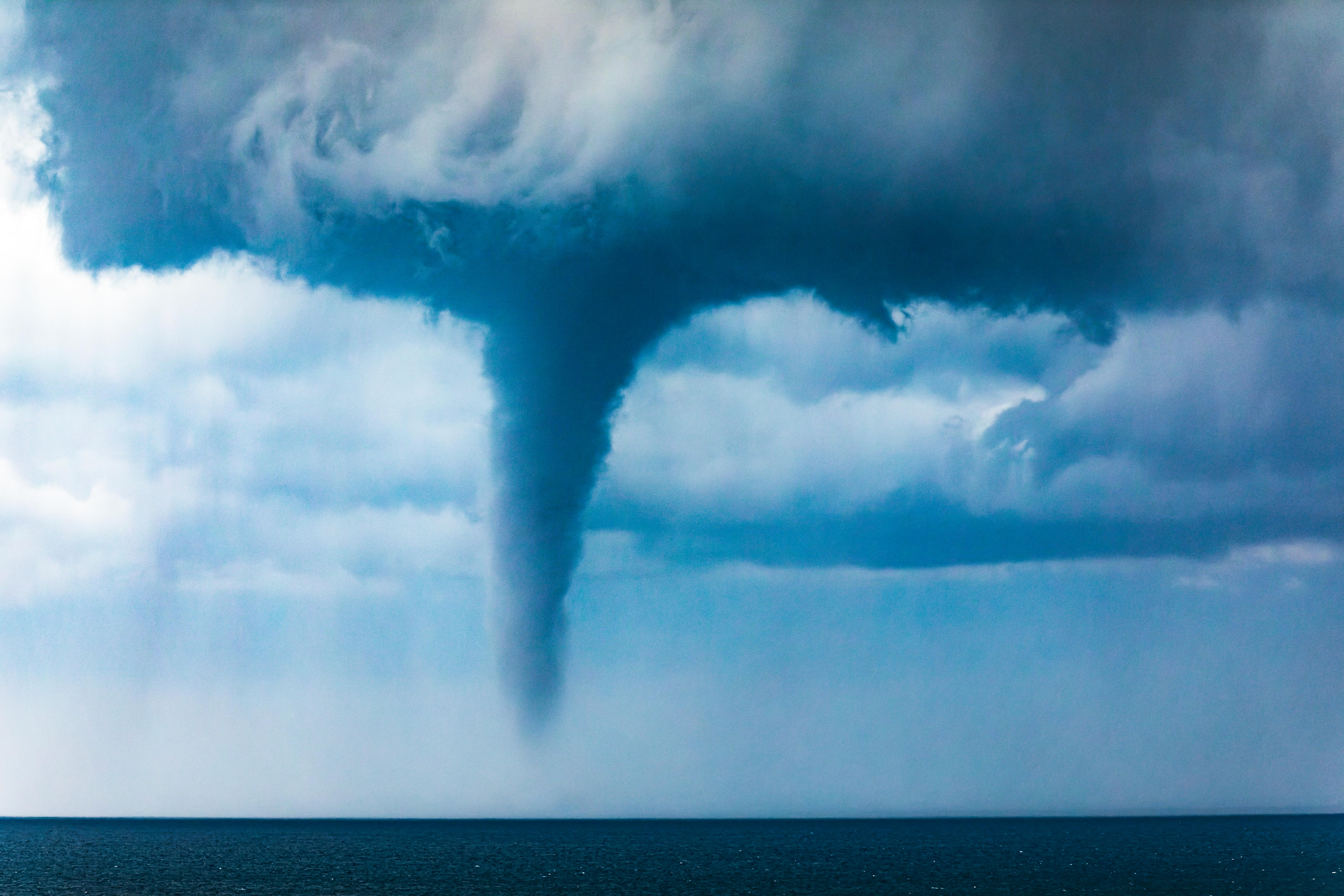 Waterspout in the ocean off the Australian coast with darkening sky, clouds and ocean