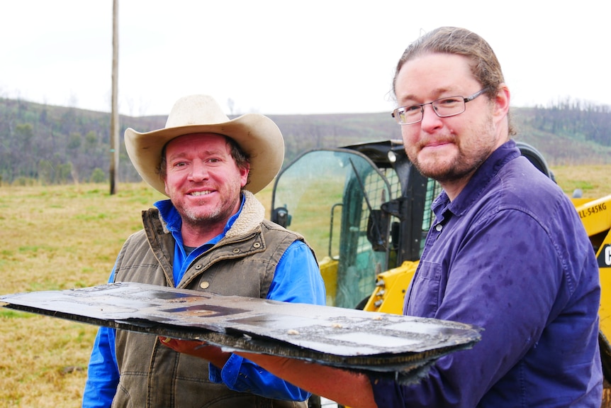Dr Brad Tucker and farmer Jordan Hobbs holding space junk