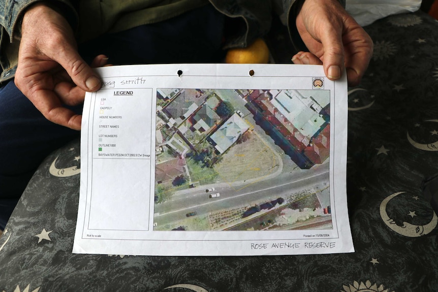 Close up of Greg's hands holding a print out of the map, with an empty space on the corner.