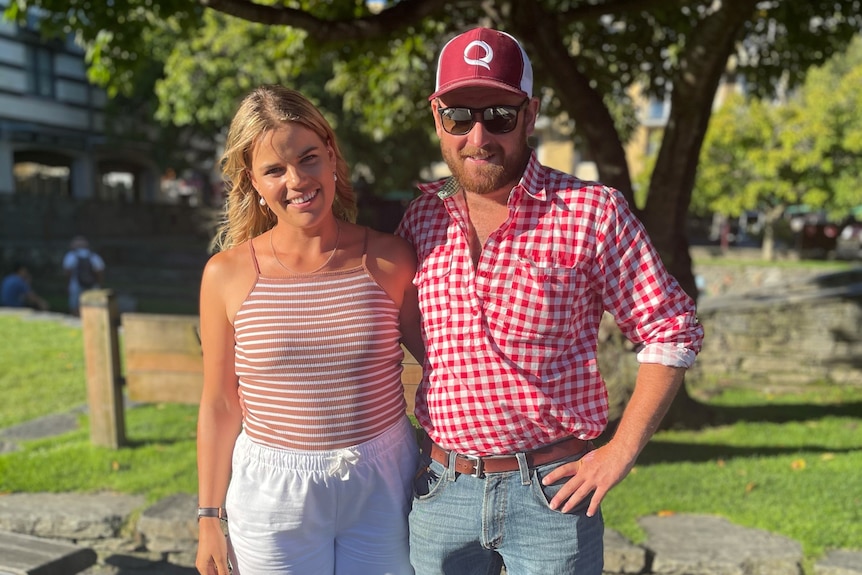 A young woman and man standing with their arms around each other