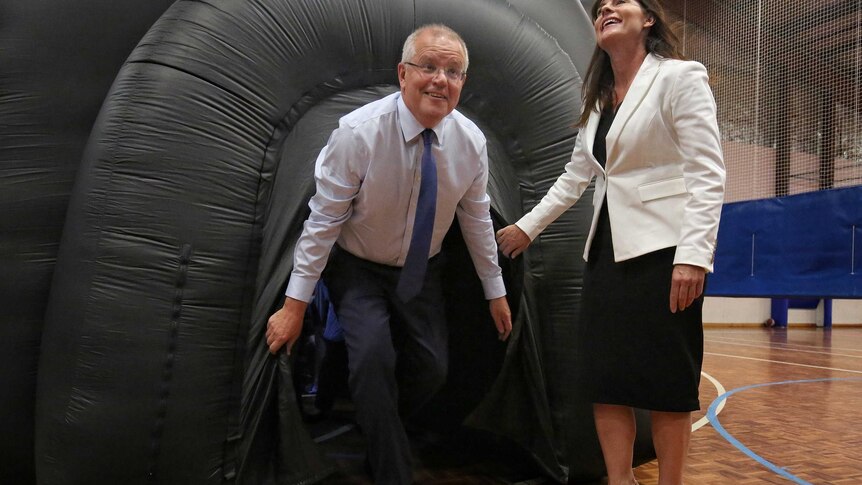 Scott Morrison emerges from a black inflatable balloon inside a gymnasium