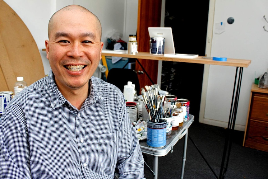 Chee Yong sitting in his art studio in Launceston