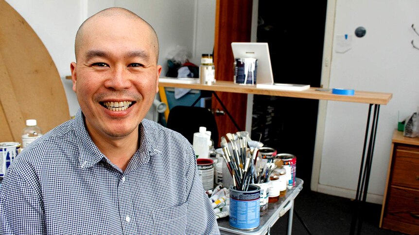 Chee Yong sitting in his art studio in Launceston