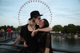 Young couple embrace in front of ferris wheel