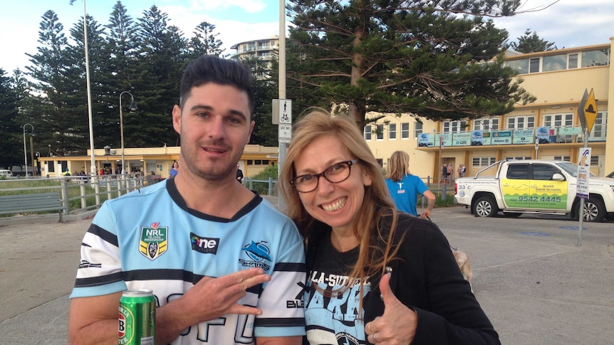 Two Cronulla Sharks fans give thumbs ups.