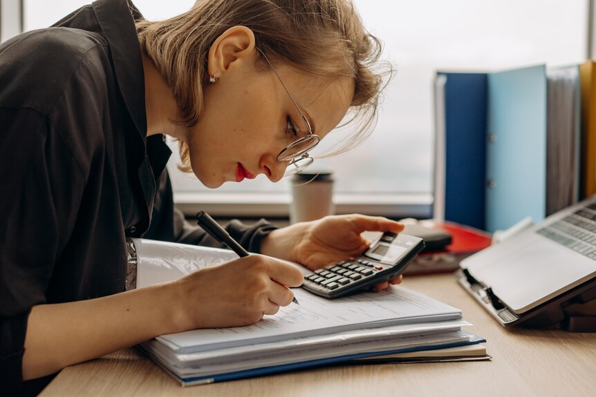 Woman concentrating on some calculations on paper
