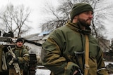 Pro-Russian separatists stand outside tank in Vuhlehirsk