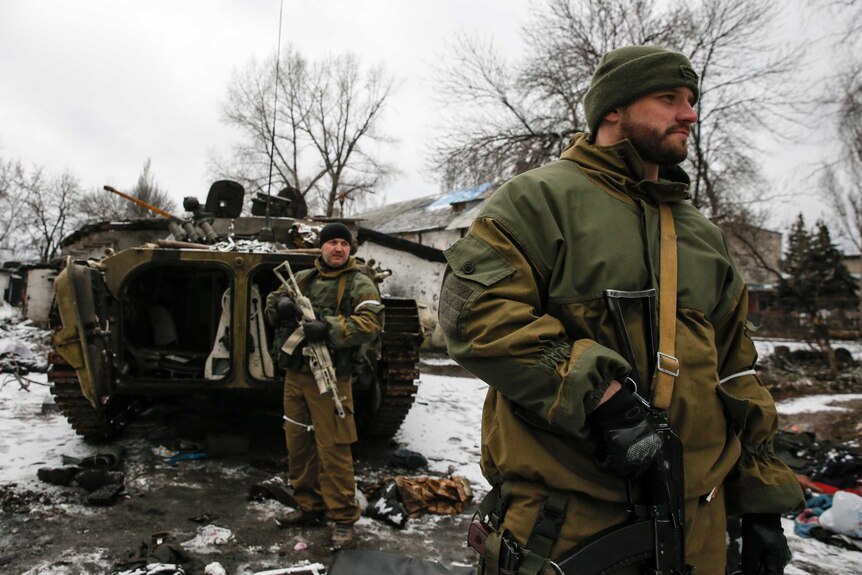 Pro-Russian separatists stand outside tank in Vuhlehirsk
