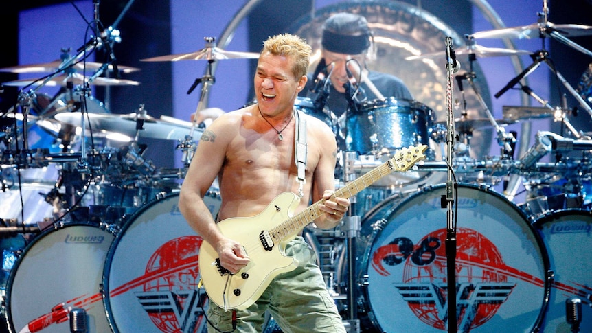 Eddie Van Halen plays guitar with no shirt on