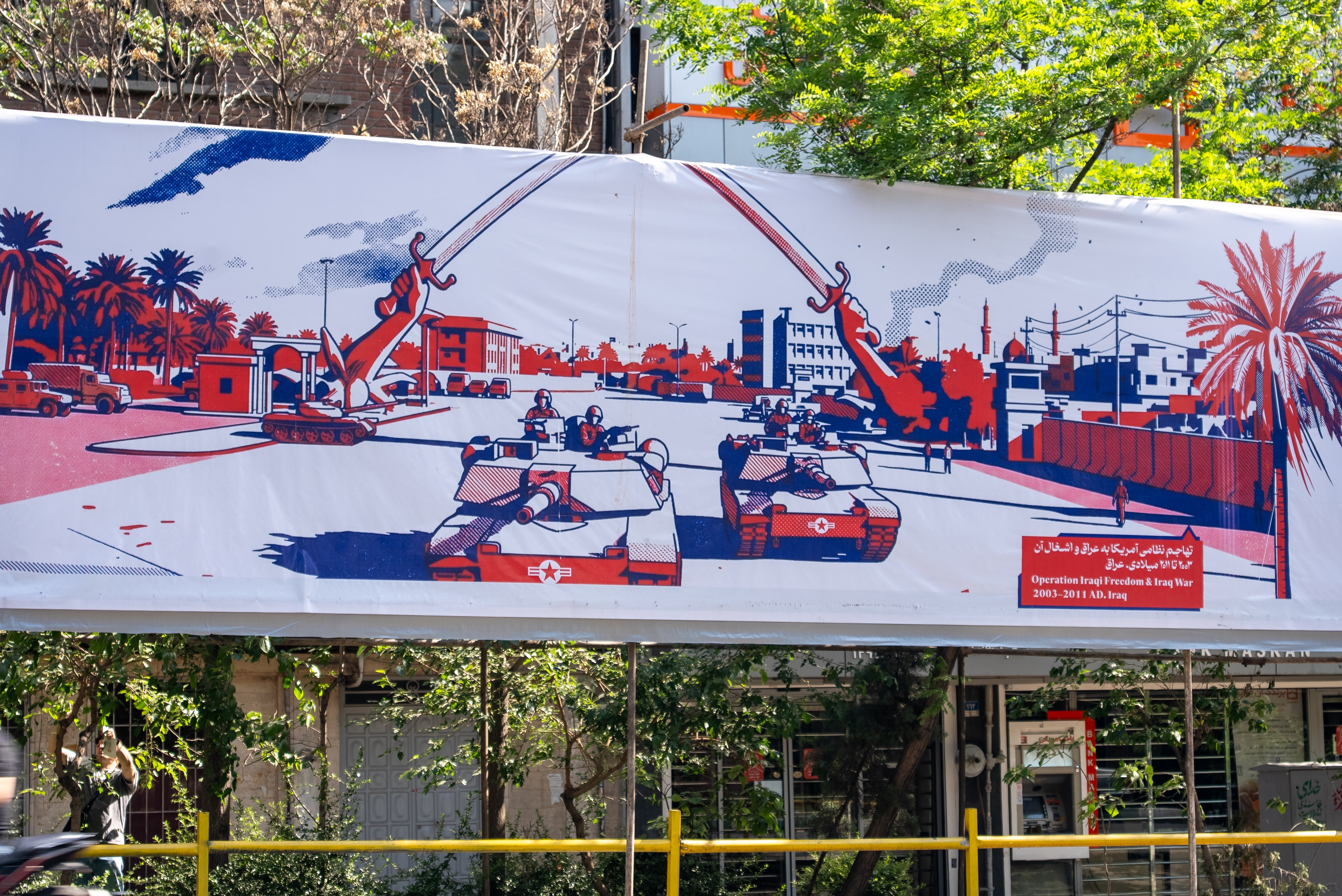 A red and blue mural depicting the Iraq War. 