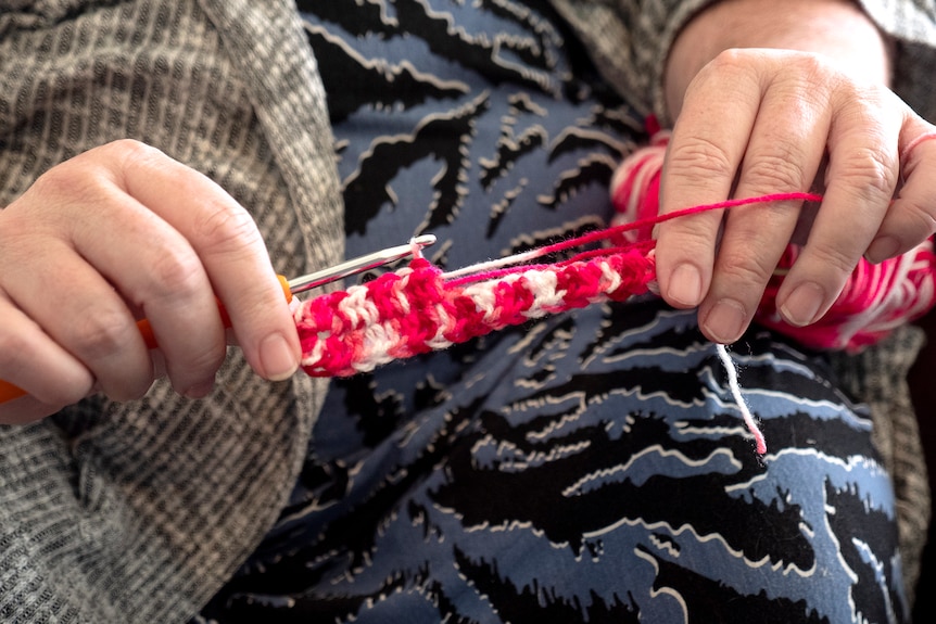 Close up of hands crocheting ear savers