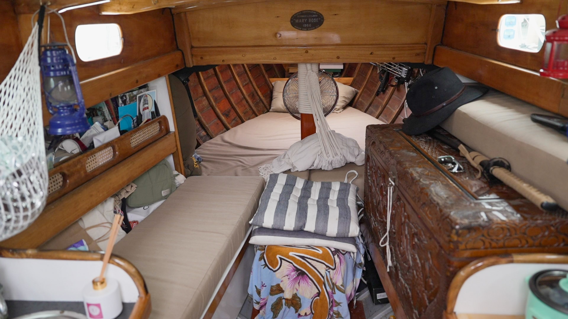 Foto del interior de un pequeño yate, incluidos espacios para dormir y almacenamiento.