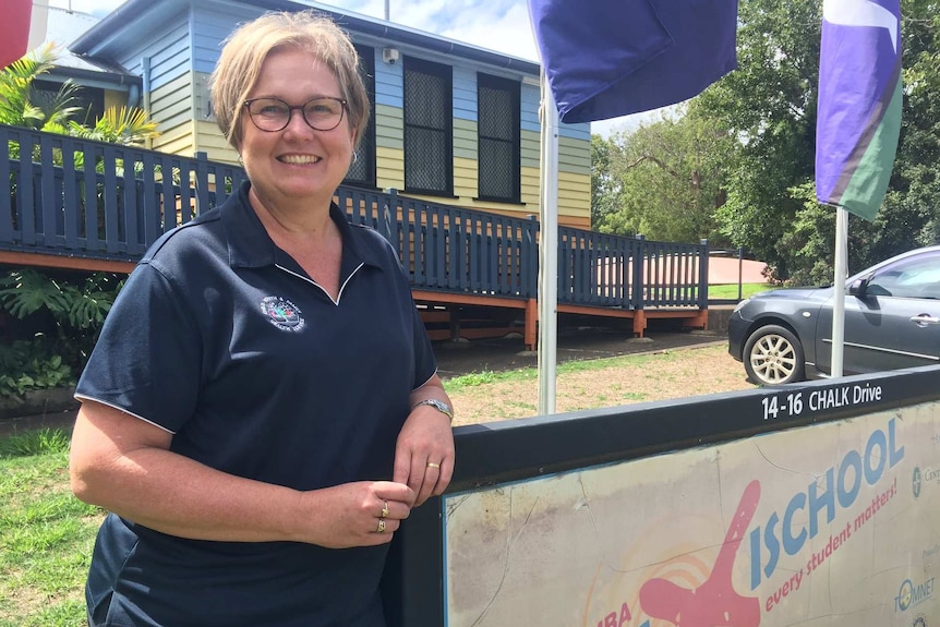 Chris Coleborn stand outside the Toowoomba school where she works.