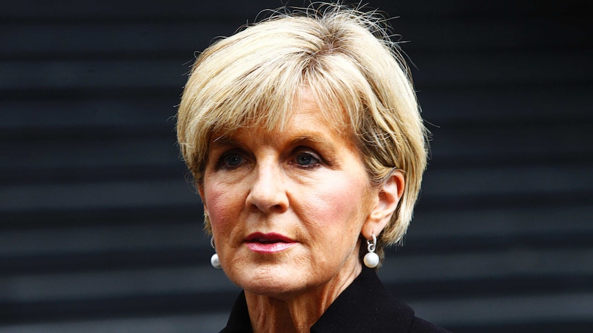 Julie Bishop attends a press conference in martin place wearing pearl earings and a high cut black blazer.