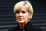 Julie Bishop attends a press conference in martin place wearing pearl earings and a high cut black blazer.