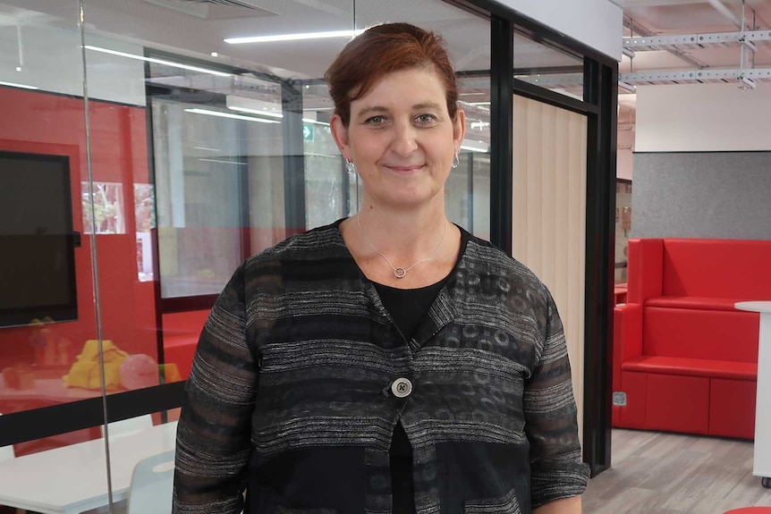 Stephanie McConnell stands next to a meeting room