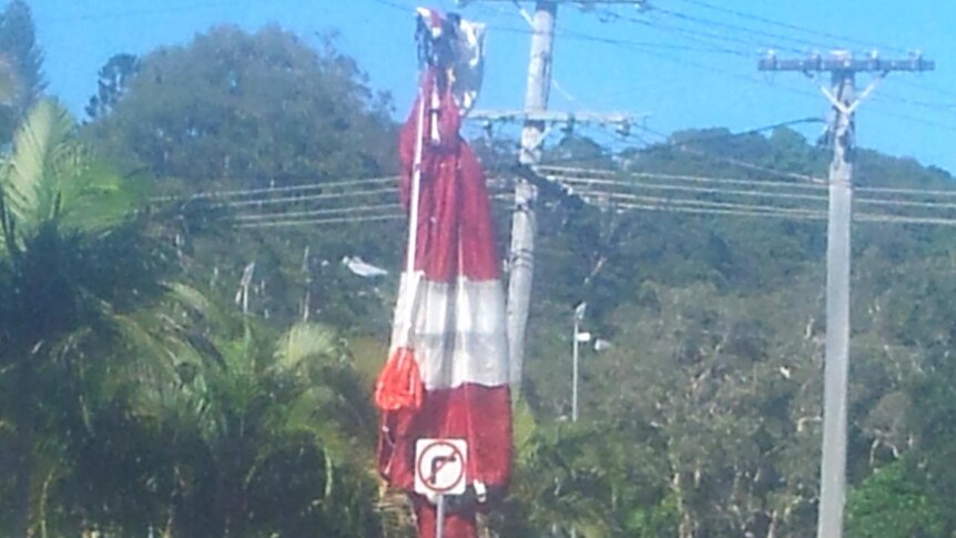 A parachute covers powerlines at Kirra after it was ditched by a skydiver due to a malfunction.
