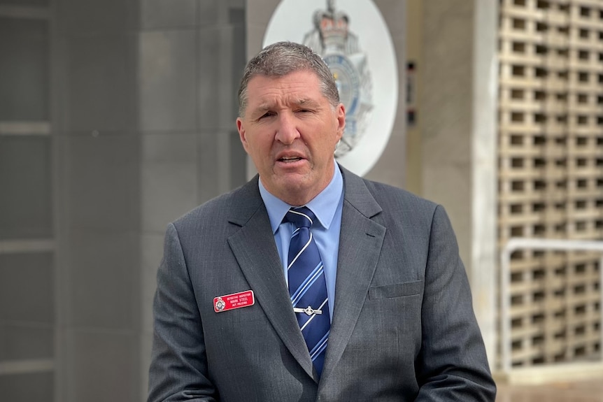 Man wearing grey suit and blue tie. 