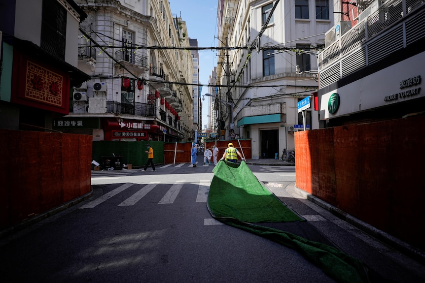 Workers dismantle barriers in Shanghai.