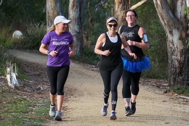 three women running and smiling.