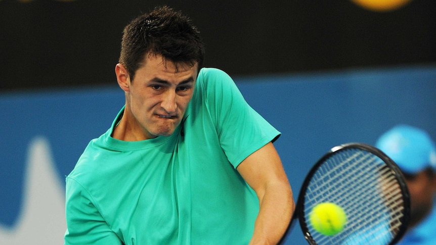 Australia's Bernard Tomic plays a backhand return against South Africa's Kevin Anderson.