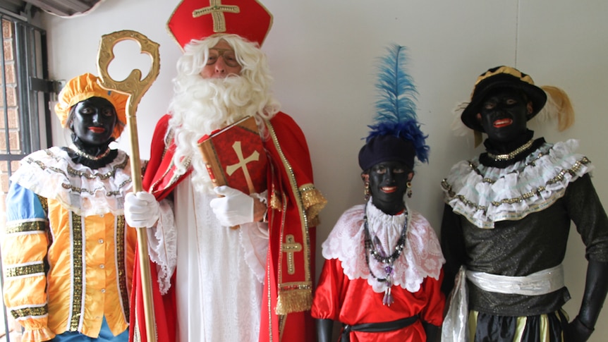 A small group of people who are dressed up for a Christmas pantomime pose for a photo