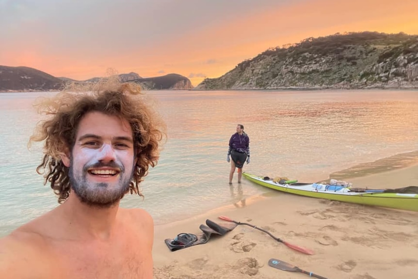 two men with kayaks on a beautiful island