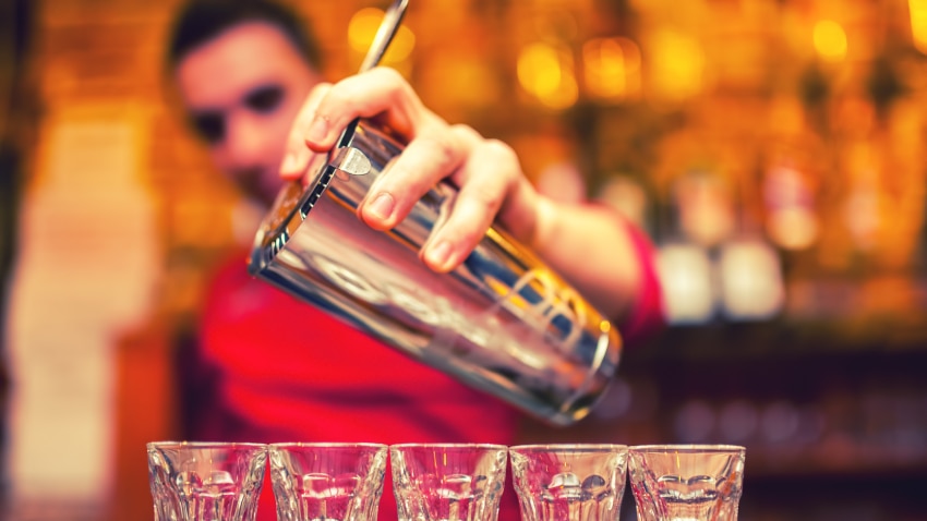 Barman pouring shots on a bar