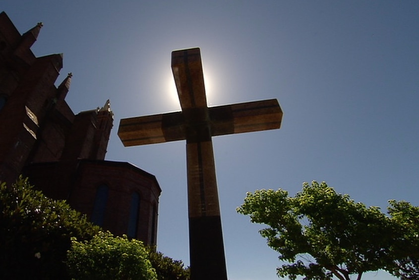 A crucifix stands outside a church.