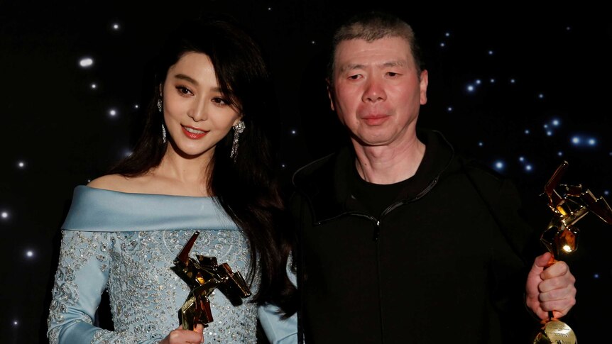 Fan Bingbing and director Feng Xiaogang hold their trophies at the Asian Film Awards