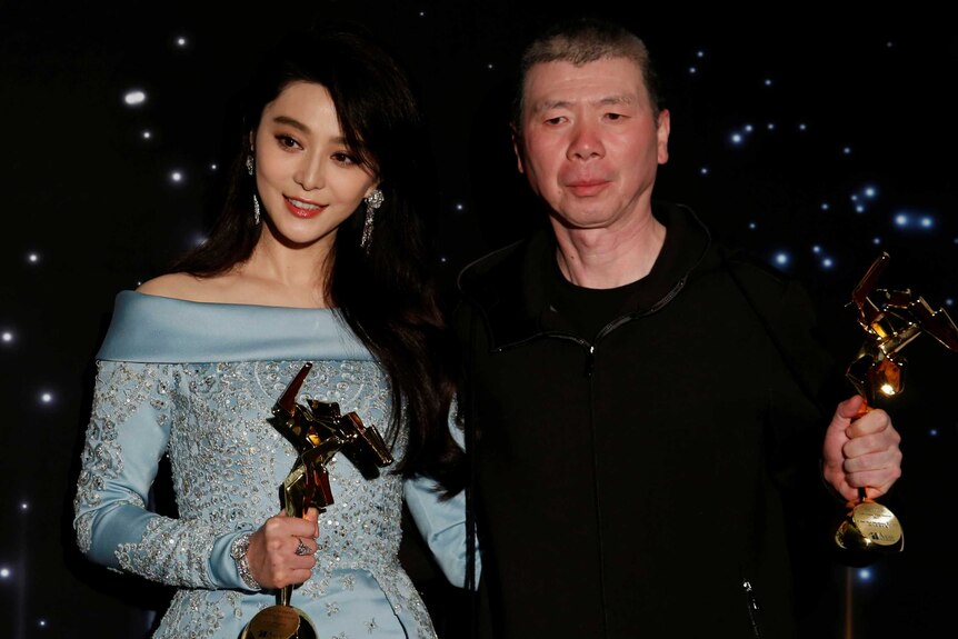 Fan Bingbing and director Feng Xiaogang hold their trophies at the Asian Film Awards