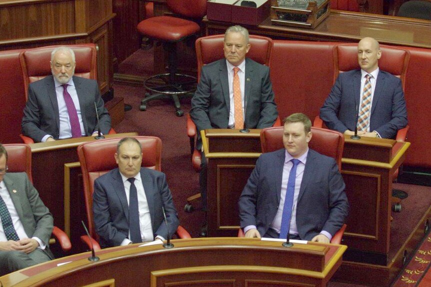 Five men in suits sitting on benches in the Upper House of WA Parliament