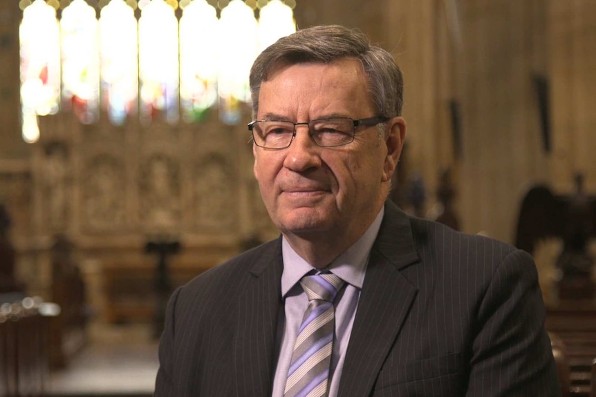 Anglican Archbishop of Sydney Glenn Davies sitting in a pew in St Andrew's Cathedral