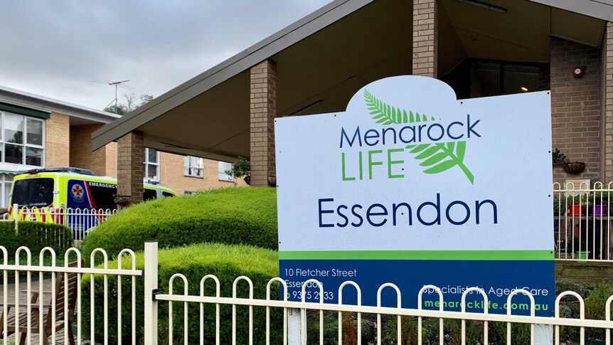 An ambulance is parked next to a brick building with a sign that reads Menarock Life Essendon out the front.