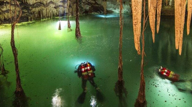 Divers explore Cenote Holtun, a sinkhole in the Chichen Itza area in Mexico.