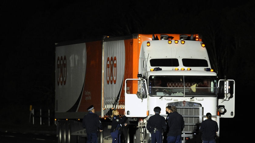 Police search the cabin of a truck after a triple shooting at KFC in Sydney.