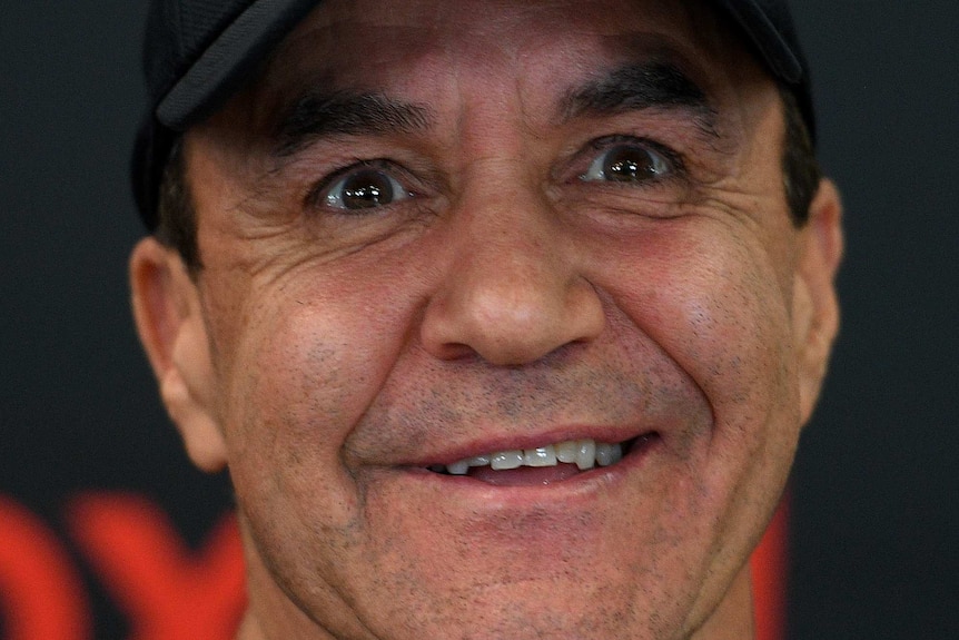 Jeff Fenech wears a black baseball cap and smiles.