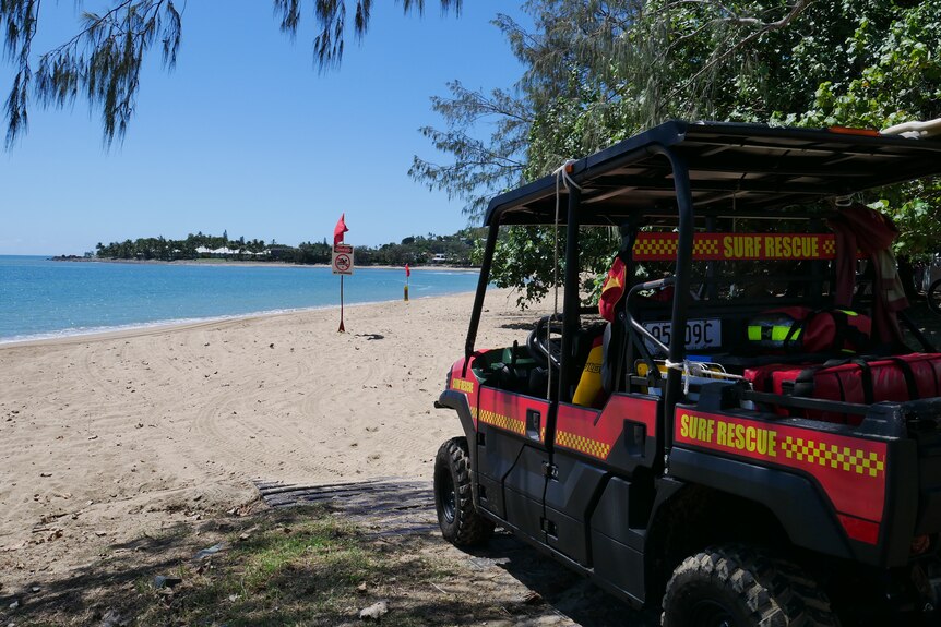 A surf lifesaving vehicle at the entry to a beach with a beach closed sign.
