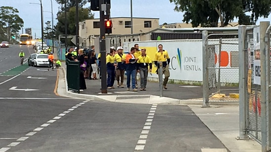 Construction workers leave the Royal Adelaide Hospital worksite.