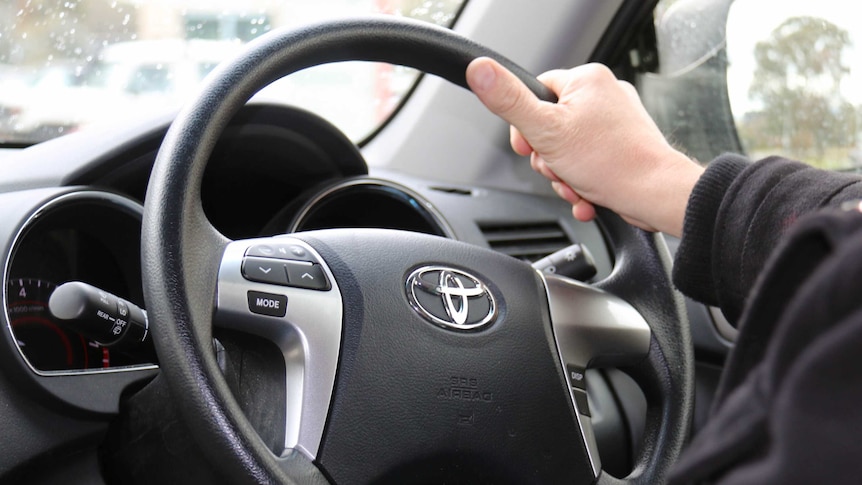 Hands on a car steering wheel
