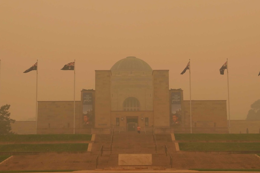 Thick orange smoke shrouds the building's facade.