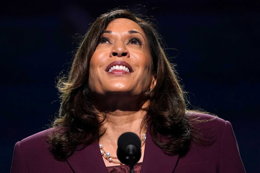 Kamala Harris smiling and looking up to the lights