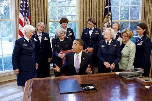 Barack Obama seated and surrounded by women in Air Force uniforms.