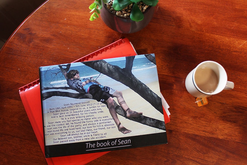 A photo taken from above shows a book about Sean Scovell sitting on a table next to a cup of tea.